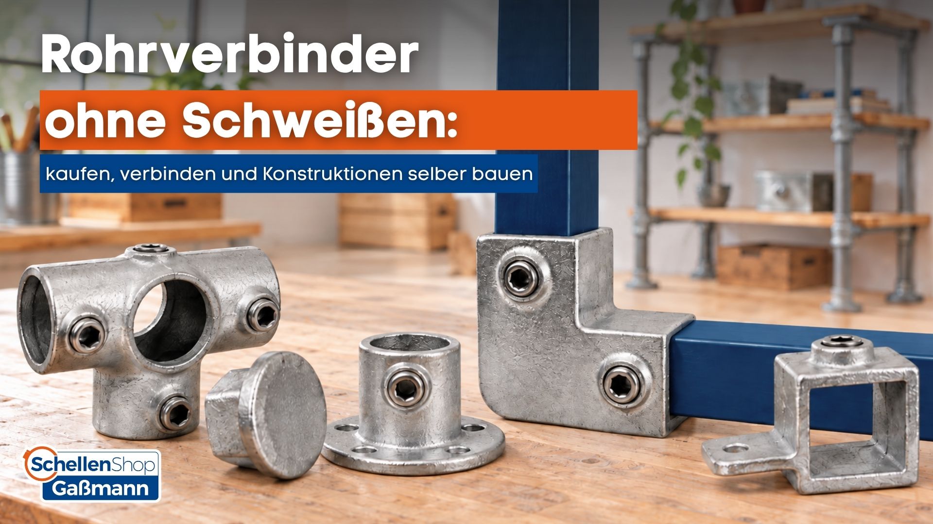 Nahaufnahme von verschiedenen silbernen Rohrverbindern ohne Schweißen von SchellenShop Gaßmann, teils lose auf einer Holzoberfläche, teils an blauen Vierkantrohren montiert. Im Hintergrund ist ein Regal aus Rohrkonstruktionen sichtbar, das die Anwendungsm