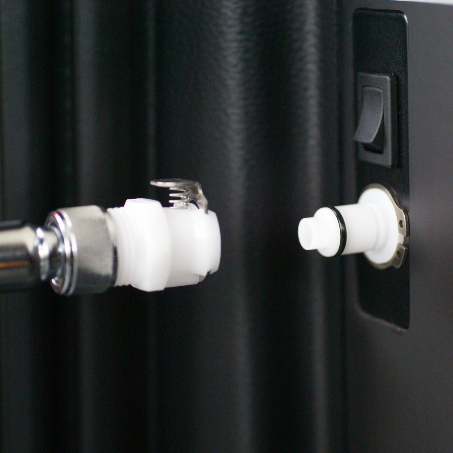 Kupplung Brause-Anschluss für Westfalia Camping Dusche: Detail der Schnellverschluss-Steckverbindung Nahaufnahme der Kupplung Brause-Anschluss für Westfalia Camping Dusche, bestehend aus einem weißen Schnellverschluss mit Chromanschluss und einer passenden weißen Einbaubuchse, die beide bereit zur Verbindung sind.
